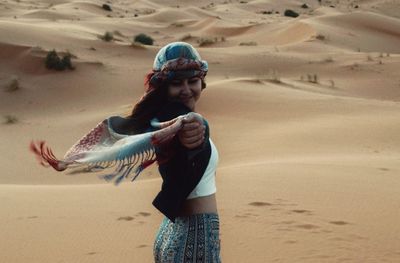 Full length of happy girl on sand at beach