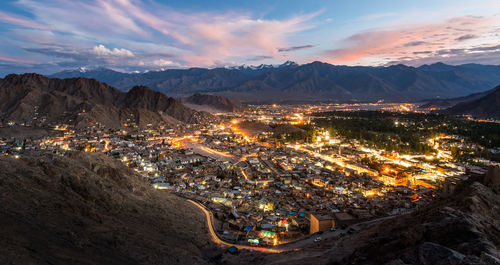 View of illuminated city against sky at sunset