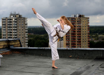 Full length of young woman standing on railing