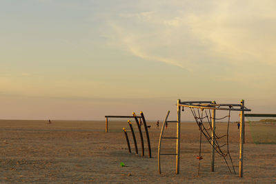 Lifeguard hut on beach against sky during sunset