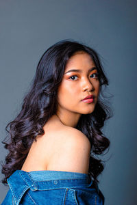 Portrait of beautiful young woman over blue background