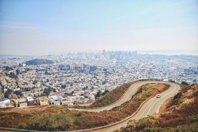 High angle view of road by cityscape against sky