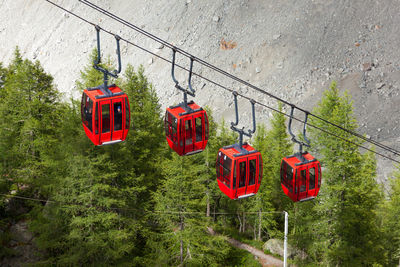 Low angle view of overhead cable car against trees