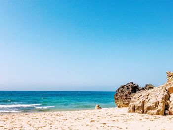 Scenic view of beach against clear blue sky