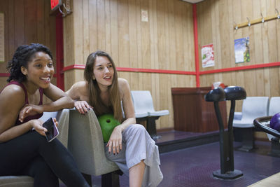 Young woman sitting on chair in corridor