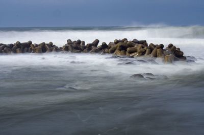 Rocks in sea against sky