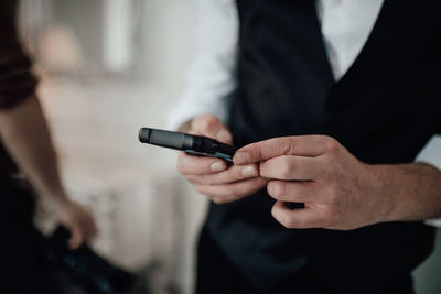 Midsection of man using mobile phone