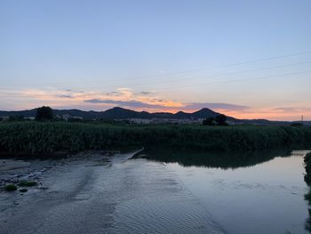 Scenic view of lake against sky during sunset