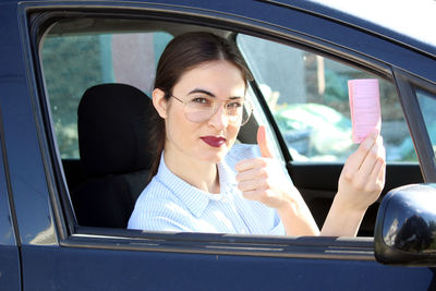 Portrait of smiling woman sitting in car