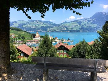 Houses by lake and buildings against sky