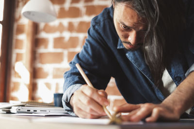 Midsection of man working on table