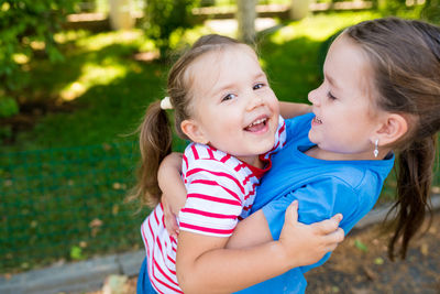 Portrait of smiling girl embracing sibling