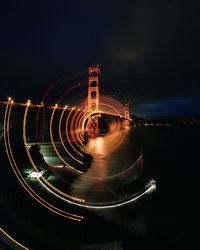 Light trails in city against sky at night