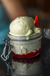 Vanilla ice cream with strawberry sauce served in a jar