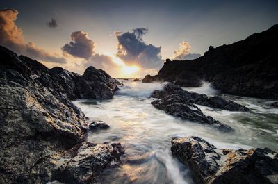 Scenic view of sea against cloudy sky during sunset