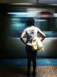 Full length of young woman standing by railing