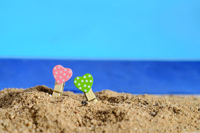 Close-up of umbrella on beach against clear blue sky