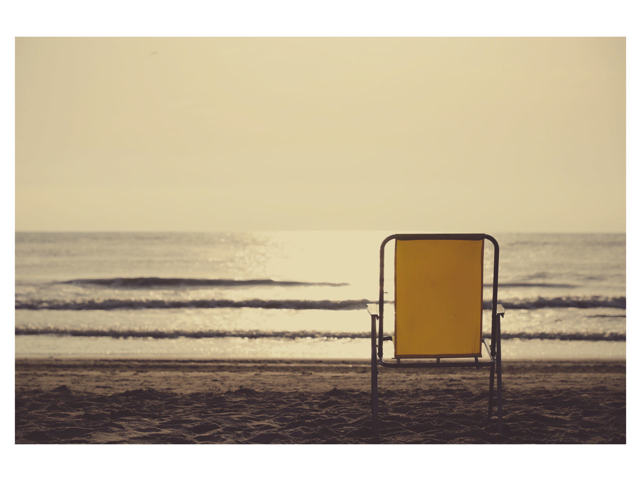 DECK CHAIRS ON BEACH AGAINST CLEAR SKY