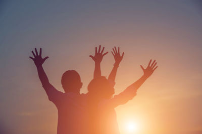 Silhouette people against sky during sunset