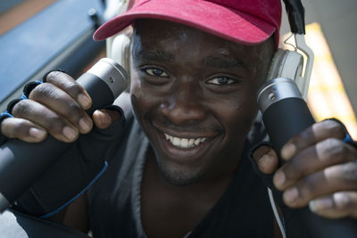 Close-up portrait of smiling man holding gym equipment