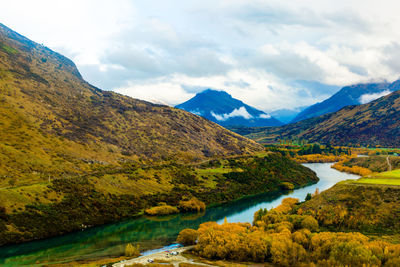 Scenic view of lake by mountains against sky