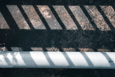 High angle view of shadow on railing by street