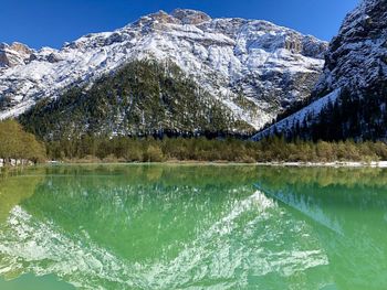 Scenic view of lake and snowcapped mountains against sky