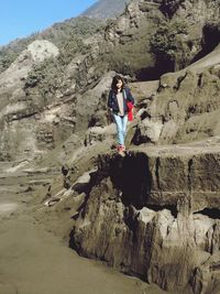 Young woman walking on rocky mountain at bromo tengger semeru national park