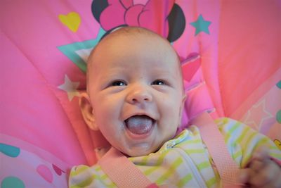 Portrait of cute baby girl lying on bed