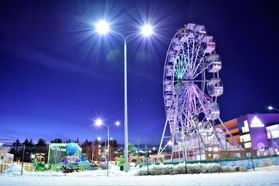 Low angle view of illuminated ferris wheel at night