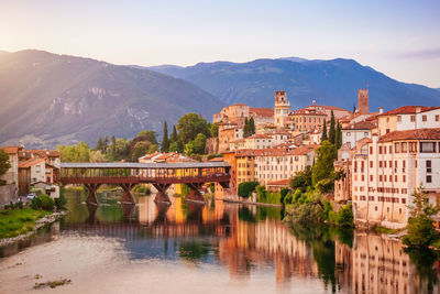 Bridge over river by mountains against sky