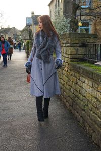 Woman walking on footpath against sky