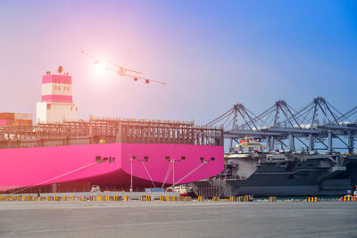 Cranes at commercial dock against sky