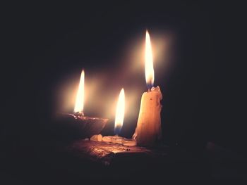 Close-up of lit candle in dark room