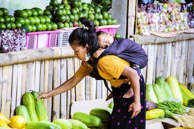 Rear view of a couple standing against fruits