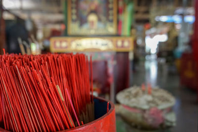 Close-up of incense sticks in container at temple