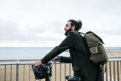 Man with e-bike having a break on beach promenade