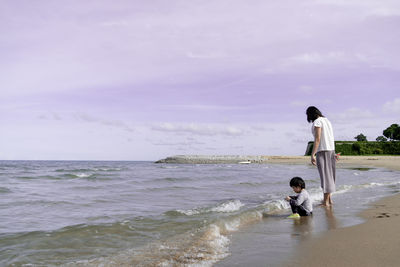 Women on beach against sky