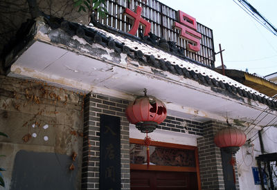 Low angle view of lanterns hanging by building