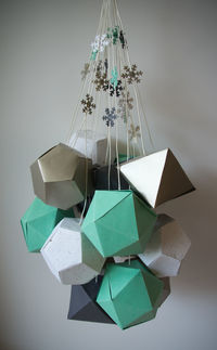 Close-up of umbrellas hanging on table against white background