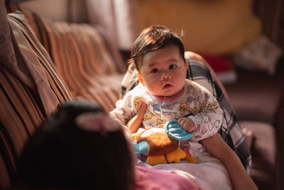 Portrait of cute baby girl with mother at home