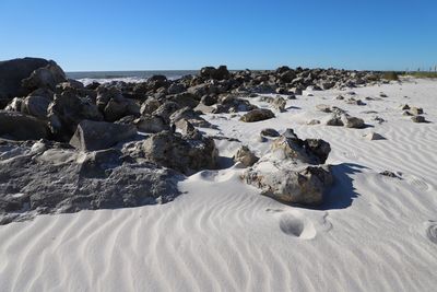 Rocks on beach against clear sky