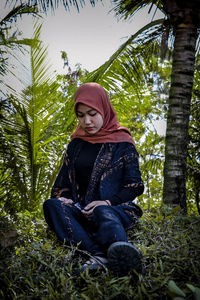 Young woman sitting on field