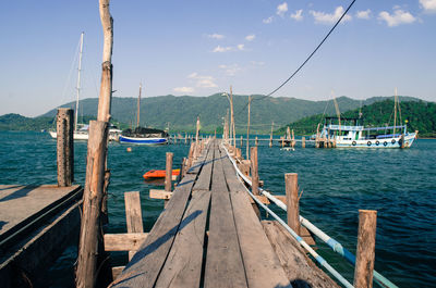Sailboats moored on sea against sky
