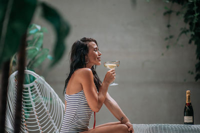 Full length of a young woman drinking glass