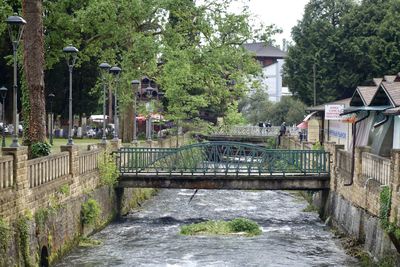 Bridge over canal amidst trees and buildings