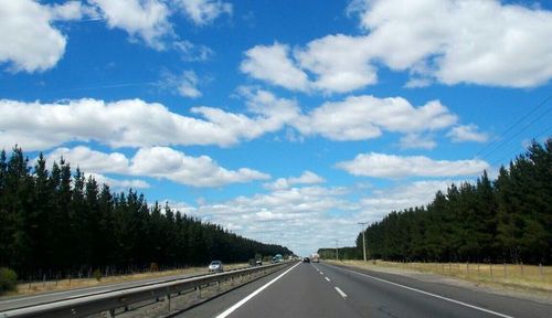 Country road against cloudy sky