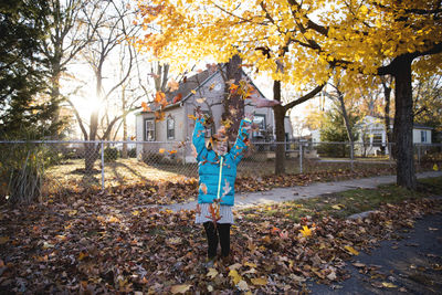 Woman standing by tree during autumn