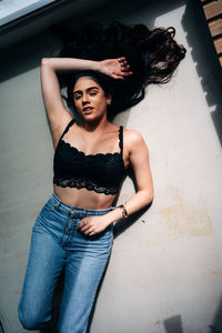 Portrait of beautiful young woman lying on floor at home