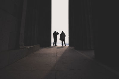 Rear view of silhouette people walking in corridor